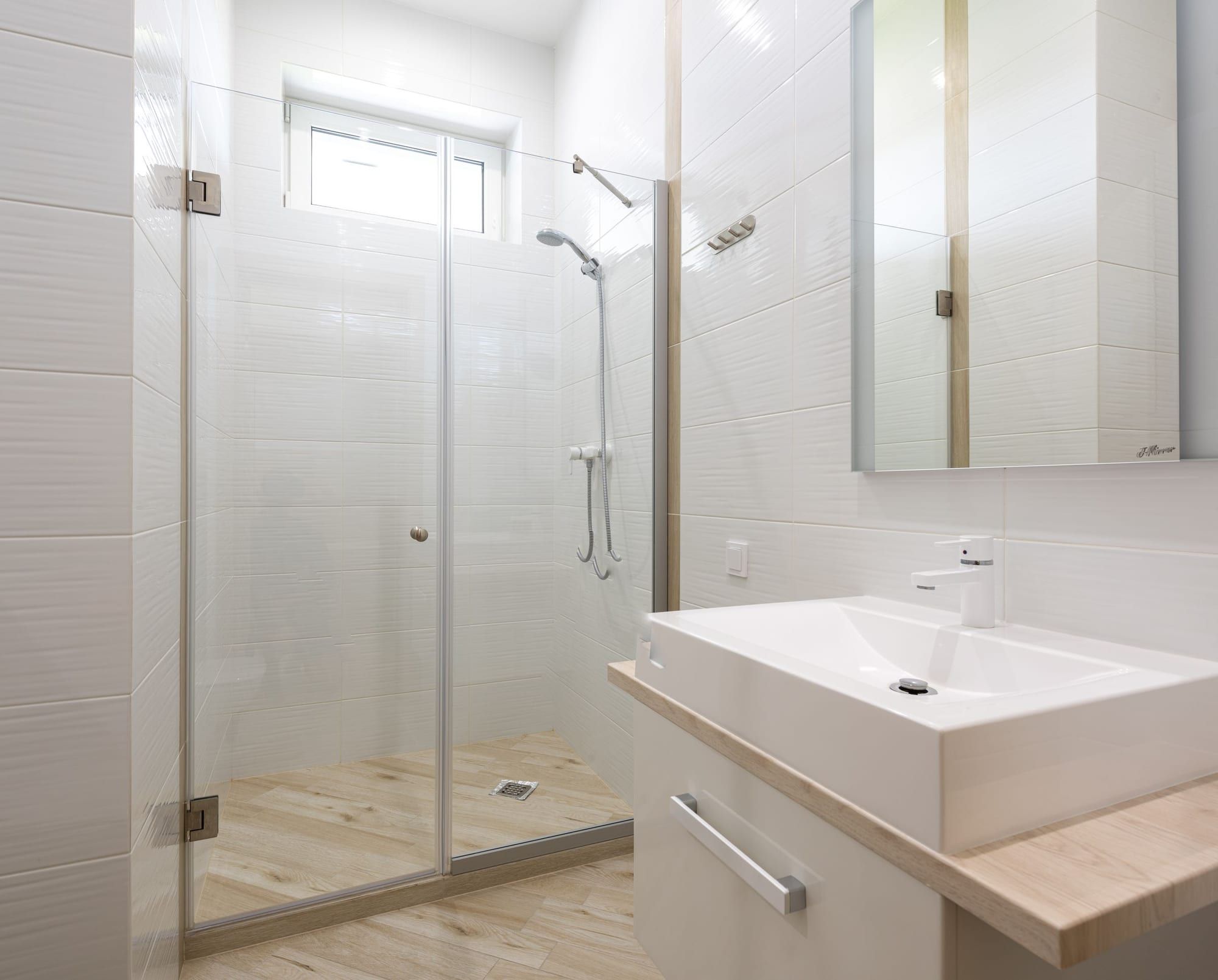Salle de bain blanche et douche vitrée sans traces après le nettoyage